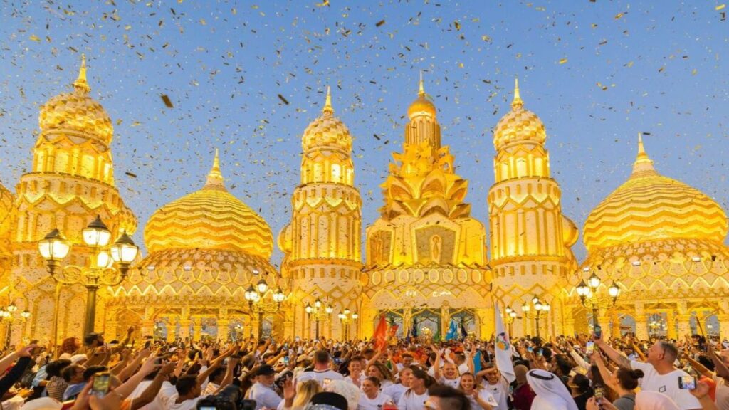 A vibrant cultural pavilion lit up at night in Global Village Dubai, featuring intricate designs and colorful lights.