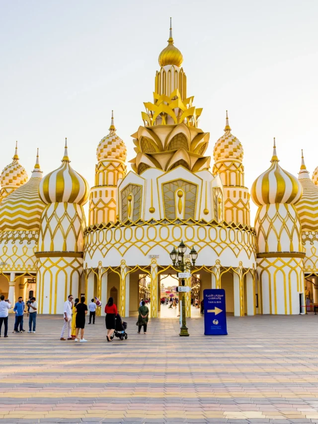 Families enjoying rides and attractions at the Global Village funfair.